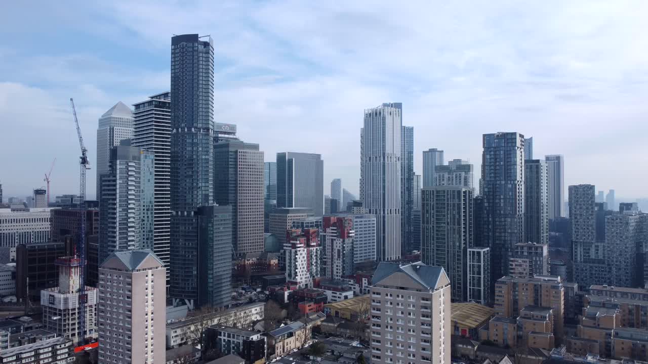 Drone flying backwards from skyscrapers on sunny English city skyline
