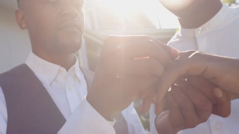 feliz pareja afroamericana de hombres homosexuales intercambiando anillos de boda, cámara lenta