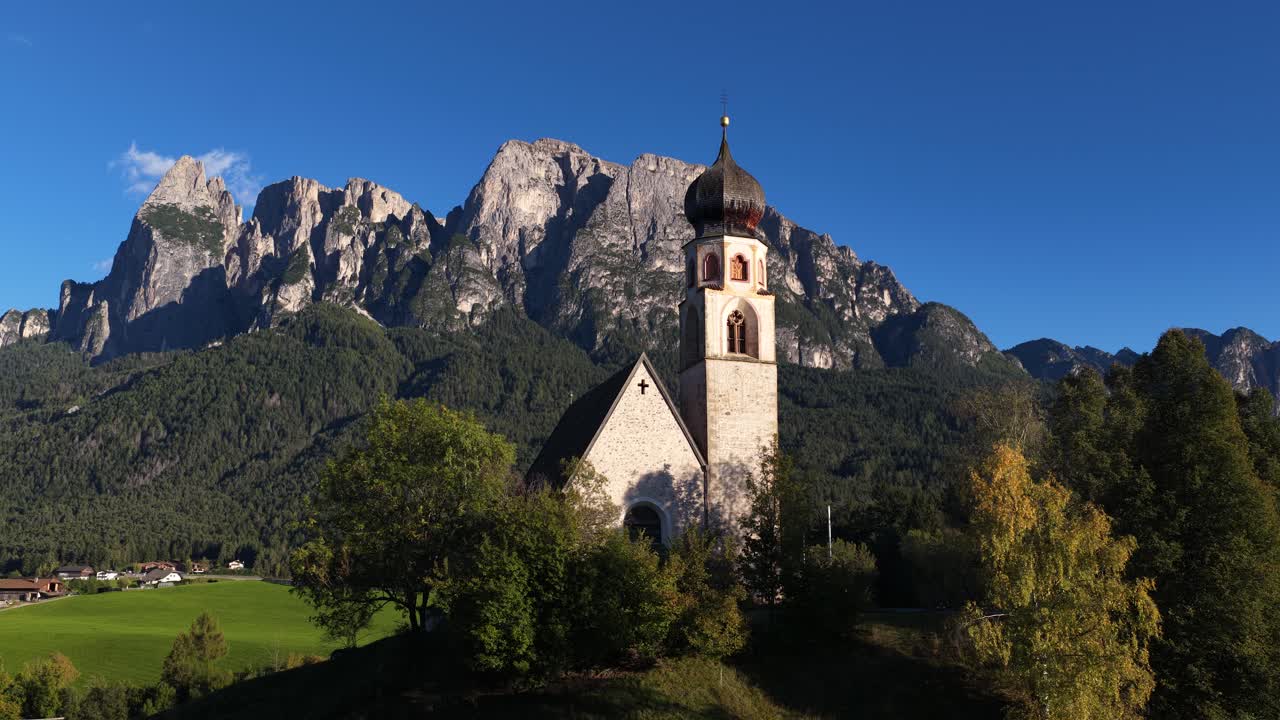 Chiesa di San Costantino and the seiser Alm, Alpi di Siusi moutain range in the italian dolomites. Aerial video