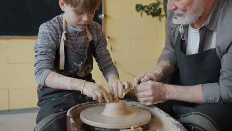 grandfather and grandson making pottery together