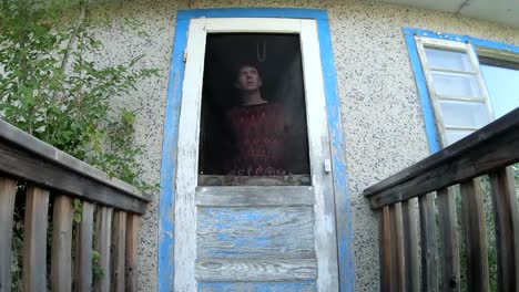 man looking out a screen door in the front of a house during the day