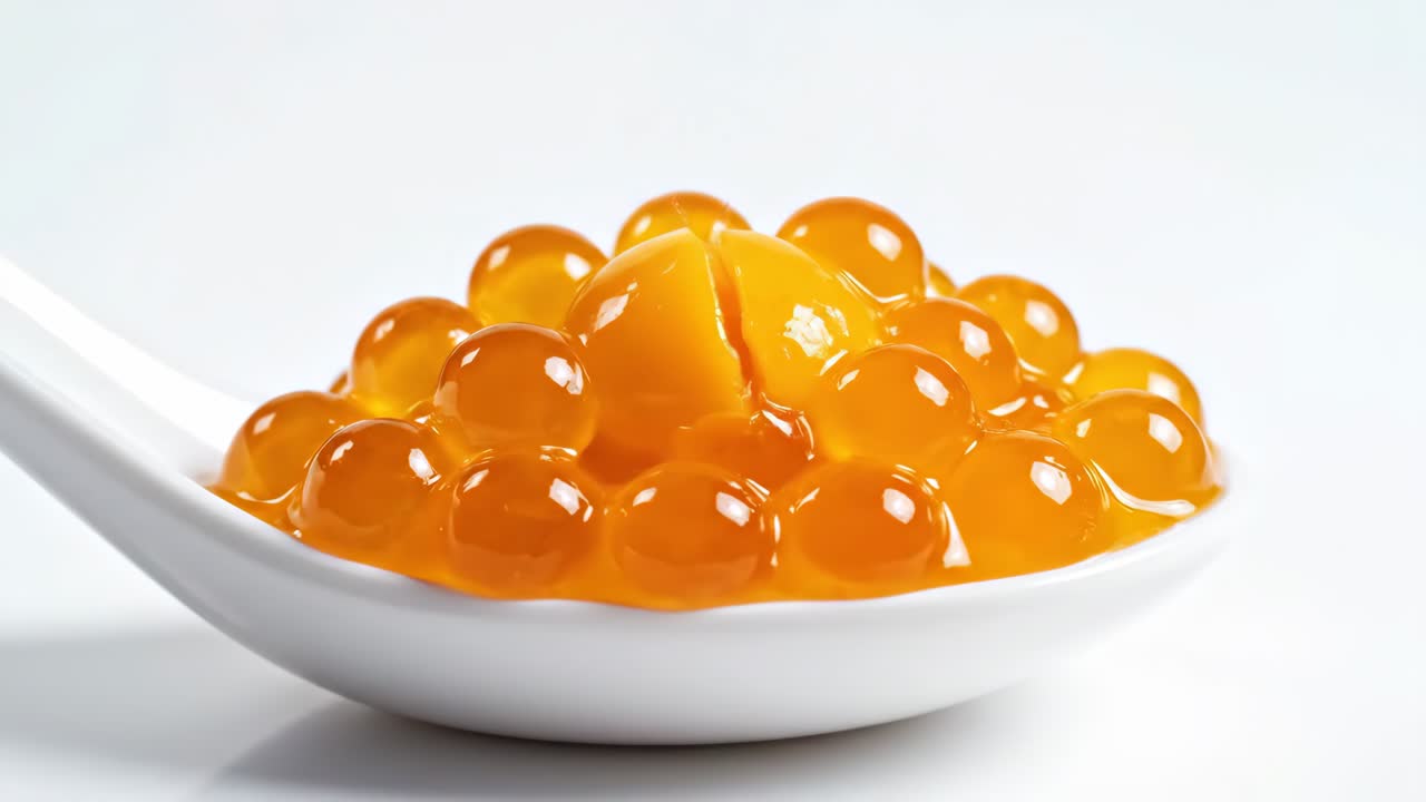 Mango Pearls Splashing on a Spoon
