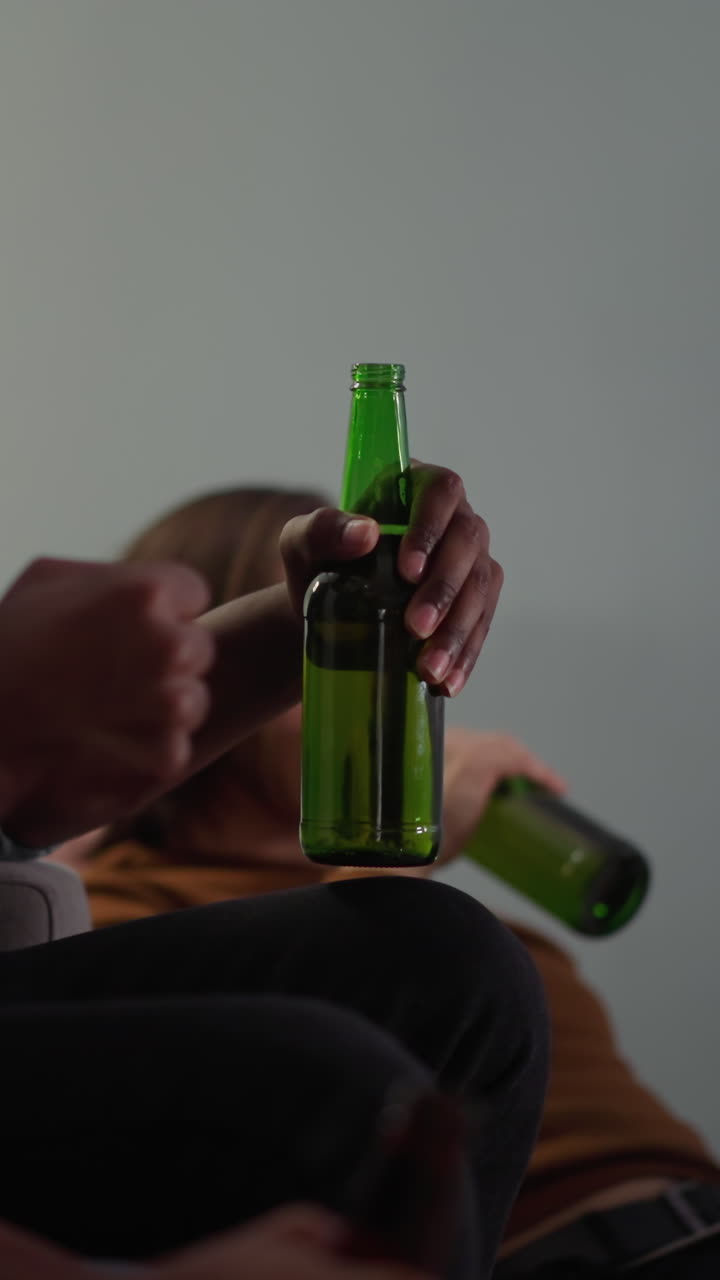 amigos beben cerveza sabrosa y disfrutan de juegos deportivos a través de la televisión gesticulando cerca de bajo ángulo disparado en cámara lenta. buen fin de semana y ocio. compañeros de trabajo relajarse y ver fútbol