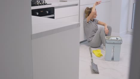 tired woman from cleaning the apartment she sits on the floor and rests