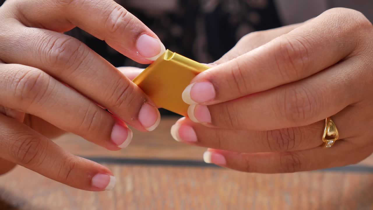 Hands unwrapping chocolate candy