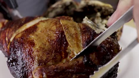 Close-up-of-chicken-half-being-cut-into-quarters