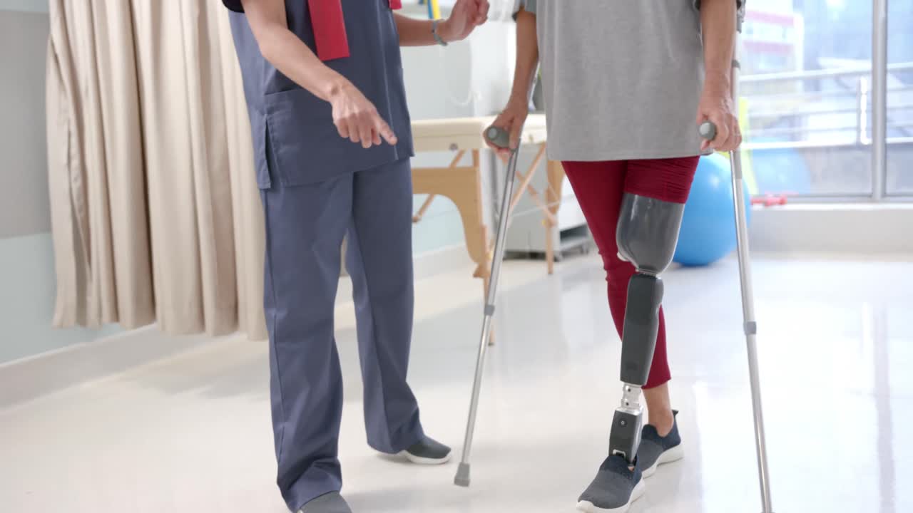 Caucasian female physiotherapist and female senior patient with prosthetic leg exercising