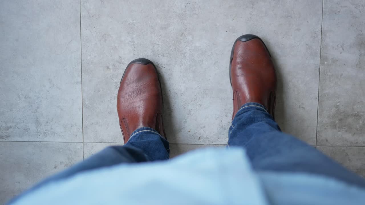 Person wearing brown leather boots and blue jeans