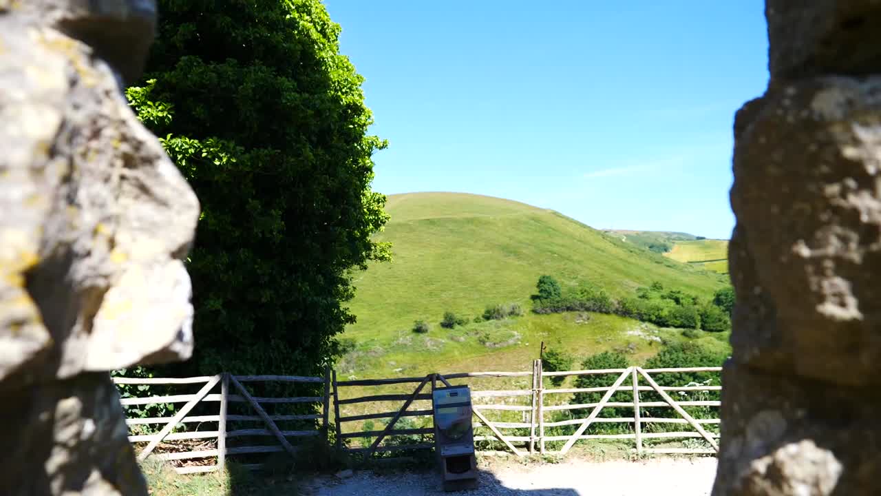 Pulling out from a window to reveal a large stone wall in castle ruins