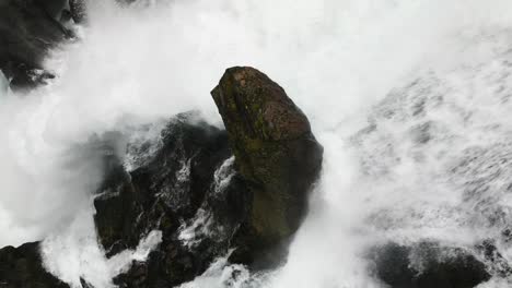 big-rock-in-the-middle-of-a-huge-waterfall,-norway,-nature,-drone