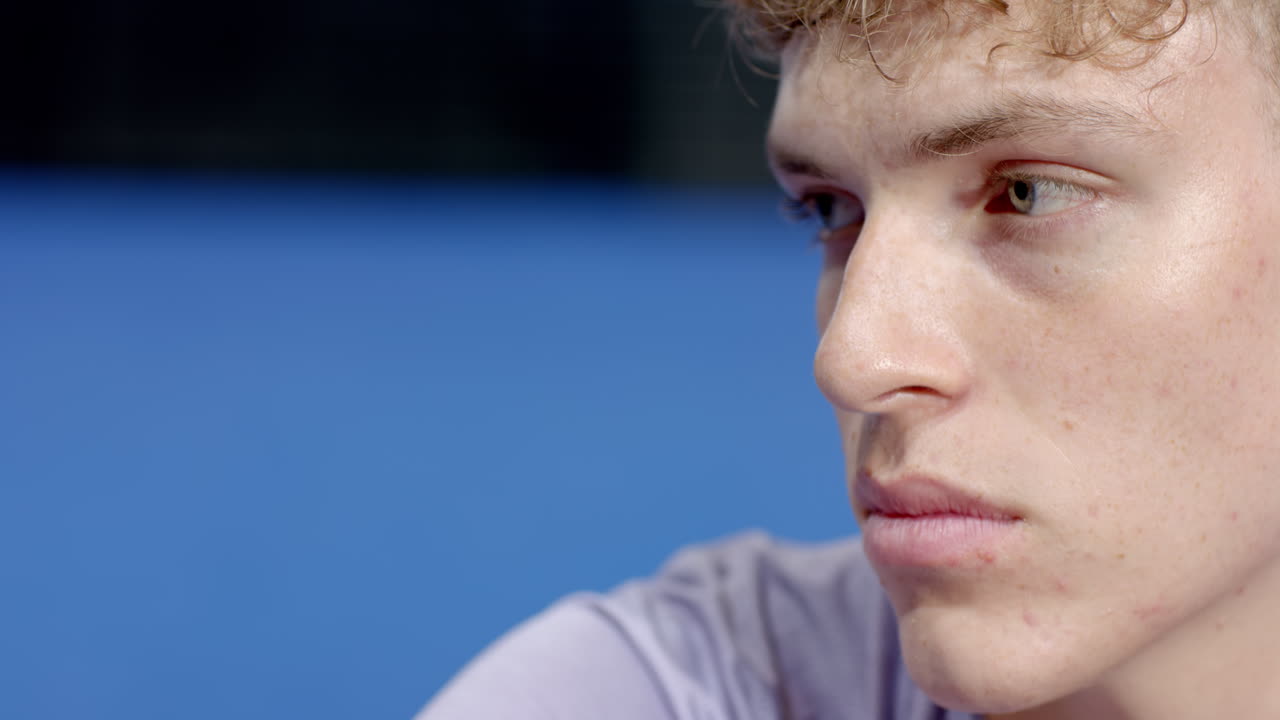 Young man concentrating intensely during padel tennis match on indoor court, copy space