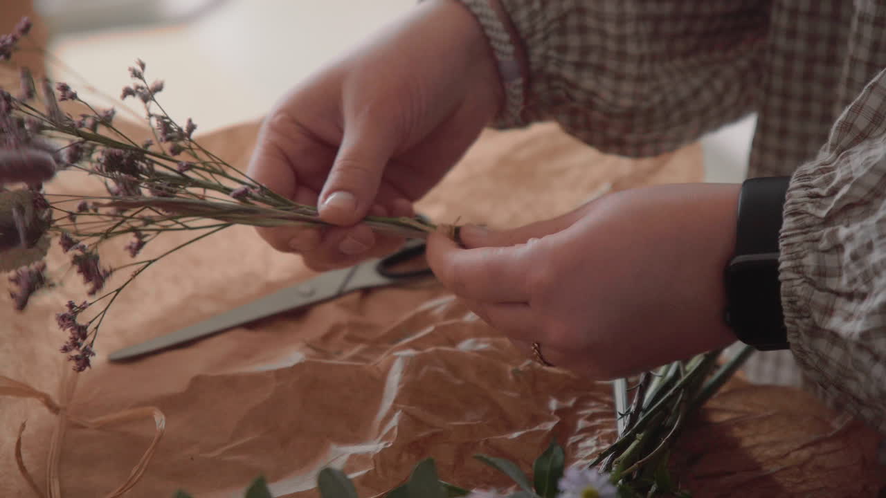 mujer joven decorando con flores frescas, ramo de flores en la mesa dentro de las manos de cerca tiro 4k