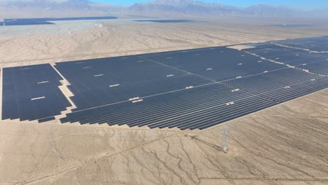 various different solar farms in arid sunny desert area panning aerial view for sustainable renewable energy generation