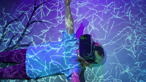 little girl laying on a floor with a vr headset, lit with glowing lights, above