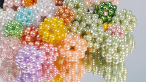 multi-colored balls of glossy beads on a mirror surface.