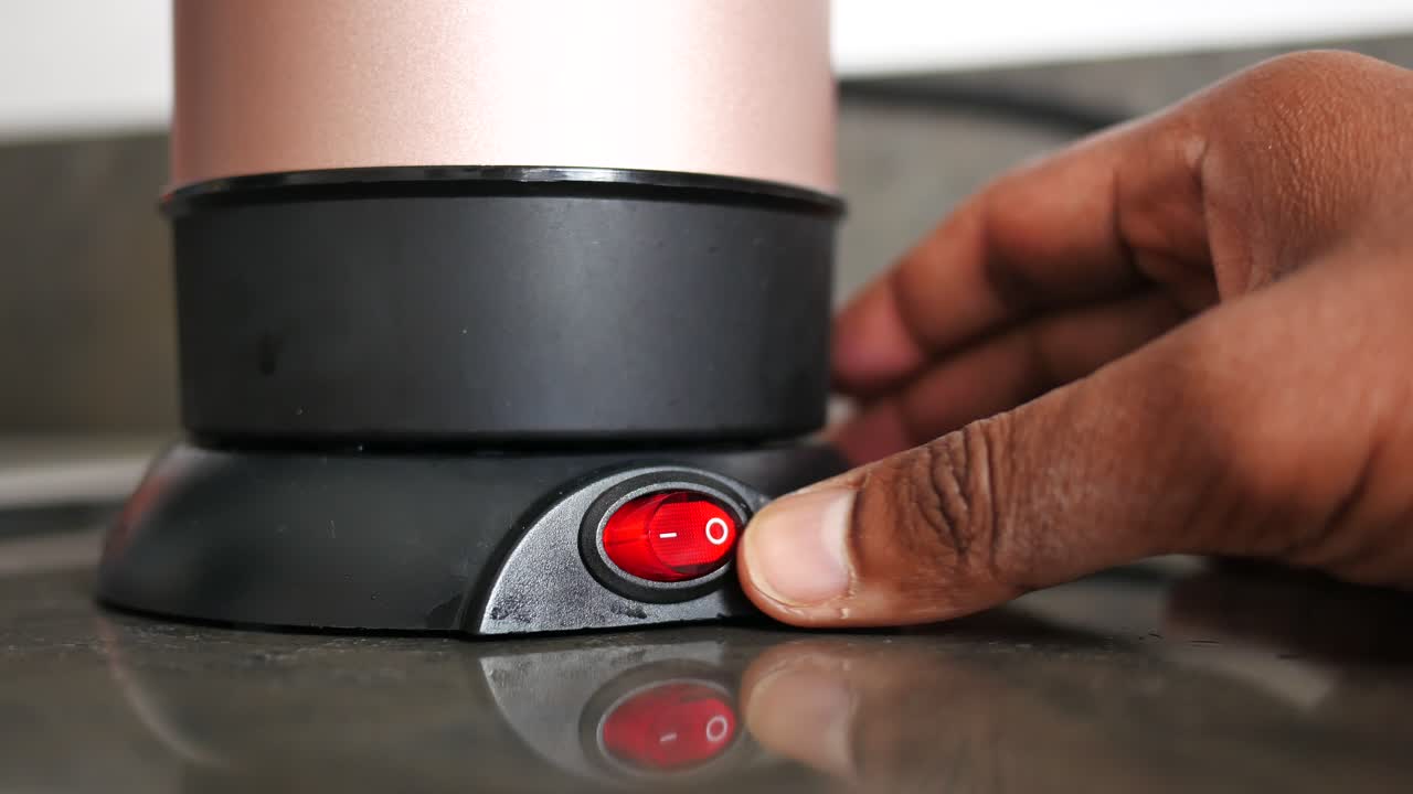작은 휴대용 커피 메이커를 켜고 있습니다.
