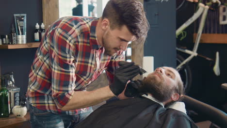 barber trimming a customer's beard