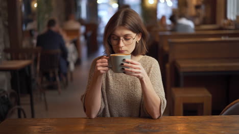 woman enjoying a hot drink in a cafe