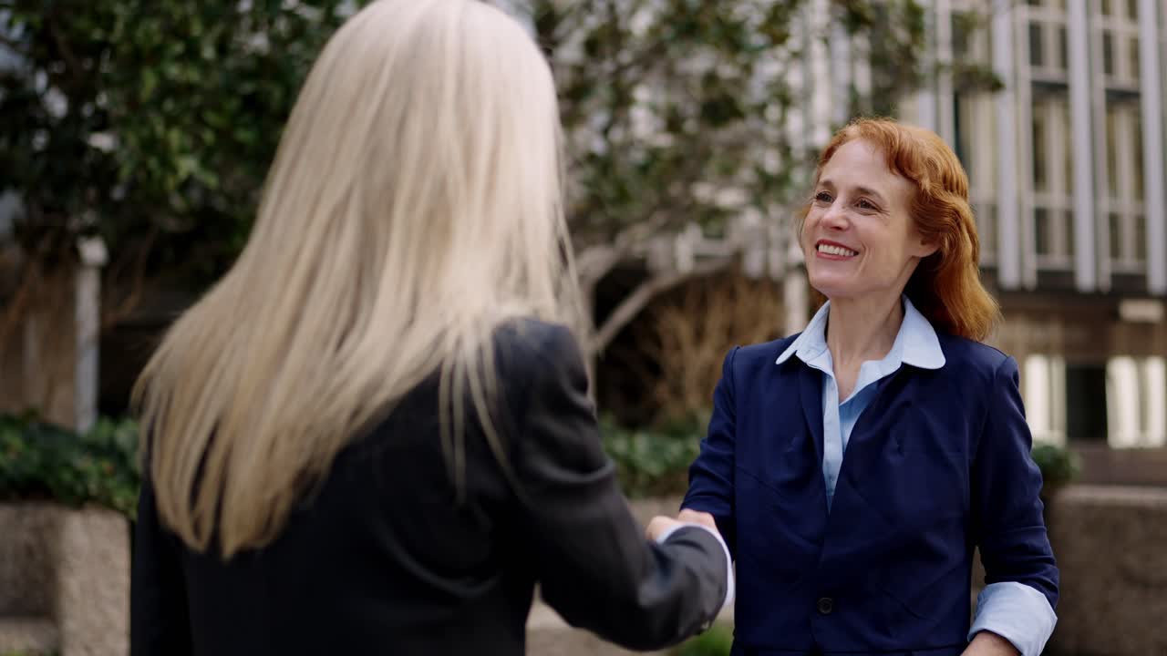 Two Businesswomen Shaking Hands Outdoors