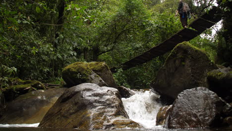 Alte-Brücke-über-Kleinen-Wasserfall-Tourist-Zu-Fuß-über-Low-Shot-Zeitlupe