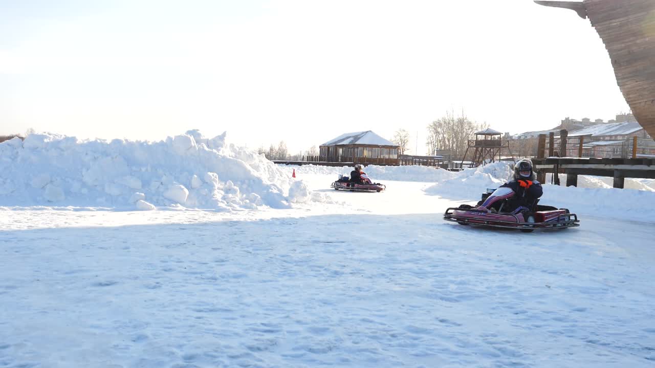 niños haciendo go-kart en una pista de hielo en invierno