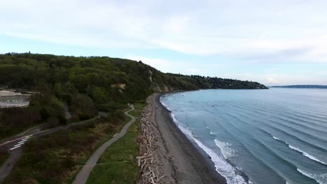 Wide-aerial-flying-down-the-Discovery-Park-shoreline-on-a-cloudy-day