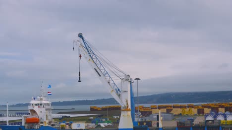crane in cherbourg harbour port next to ship docked being loaded ready to transport cargo 4k
