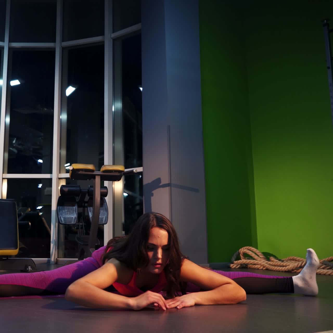 Young sporty woman stretching at gym. Healthy lifestyle in fitness club.