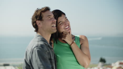 una joven pareja multirracial pasando tiempo en la orilla del mar.