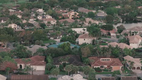 Drone-Descendente-Panorámica-De-Casas-De-Florida-Y-Palmeras-Al-Amanecer