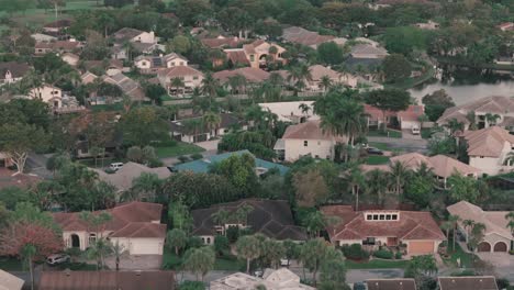 drone descending pan up shot of florida houses and palm trees at sunrise