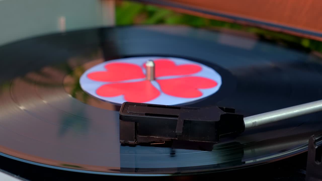 중앙에 은 심장을 가진 검은 비닐 배경, 고고학 레코드 플레이어, 바늘과 함께 회전하는 판 및 스타일러스, 인기있는 디스코 트렌드