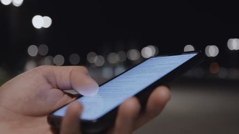 person using a smartphone at night in a city