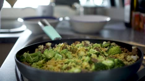Sprinkling salt on dish rice broccoli, curry and meat in kitchen of motorhome