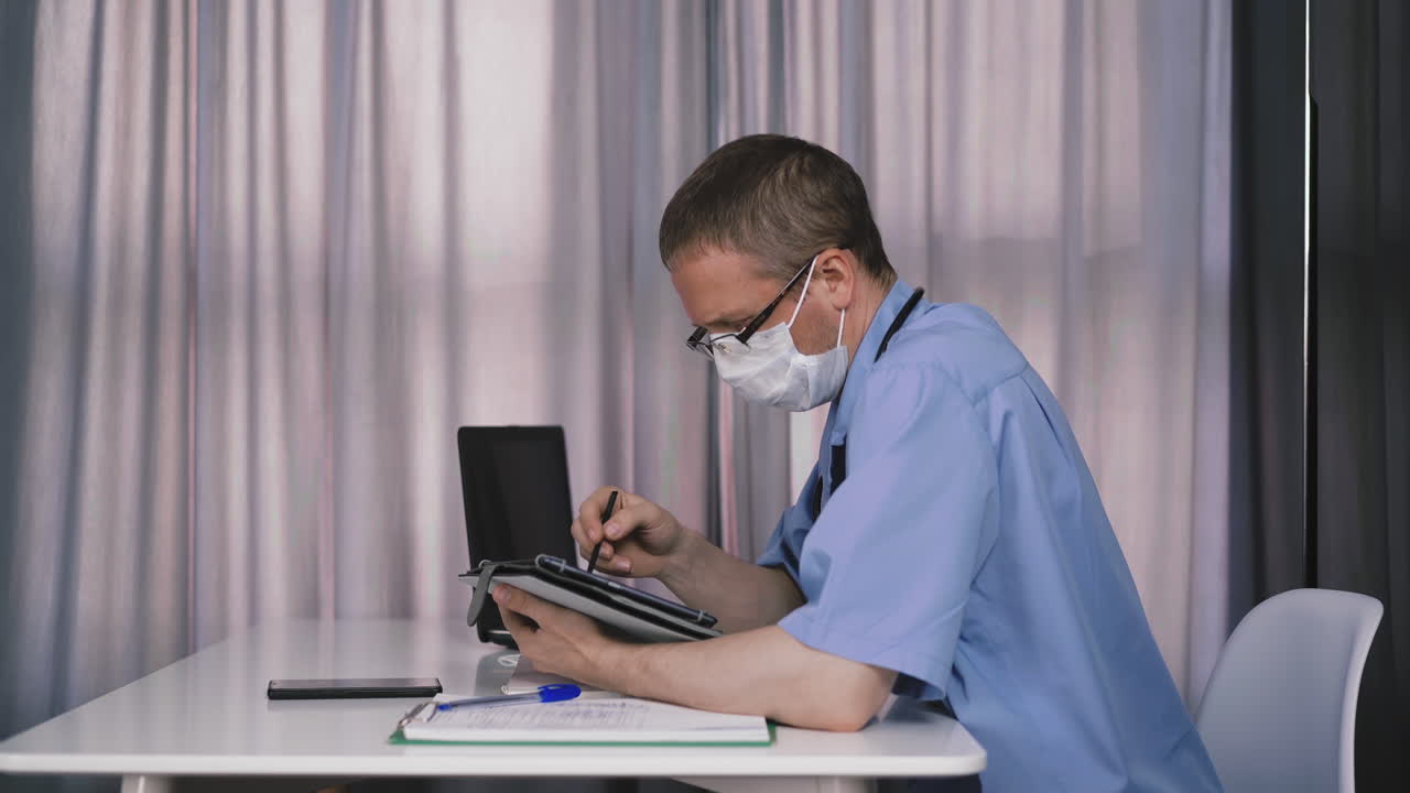 joven médico sentado a la mesa en su oficina