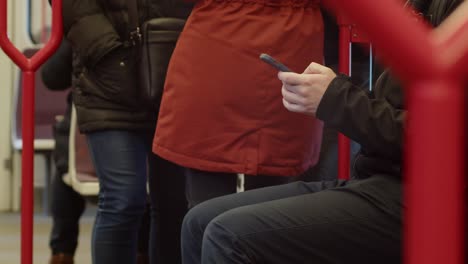 A-man-on-the-subway-is-texting-on-his-cell-phone