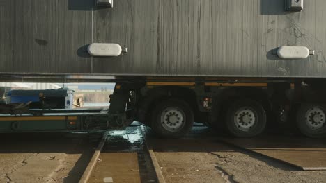 truck with heavy cargo slowly rolling across tracks, close up