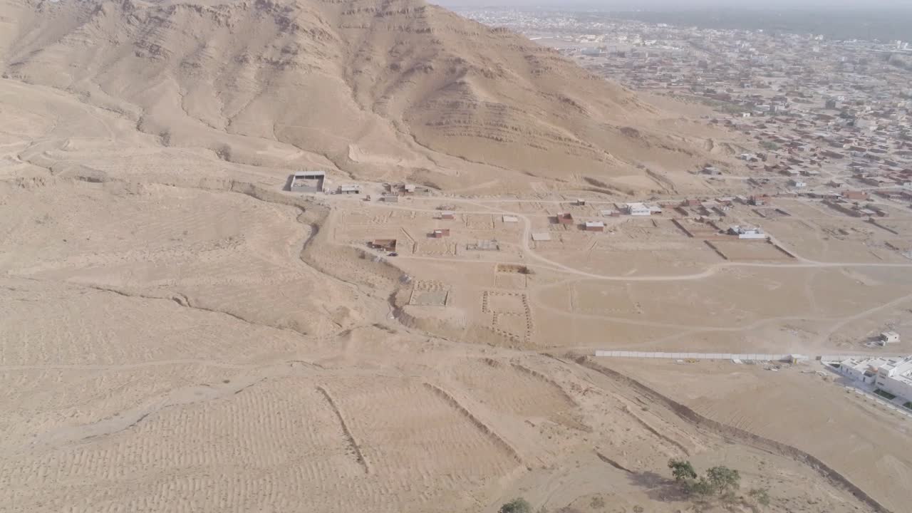 Aerial shot of a Tunisian city surrounded by arid landscapes, highlighting the mix of residential and undeveloped plots