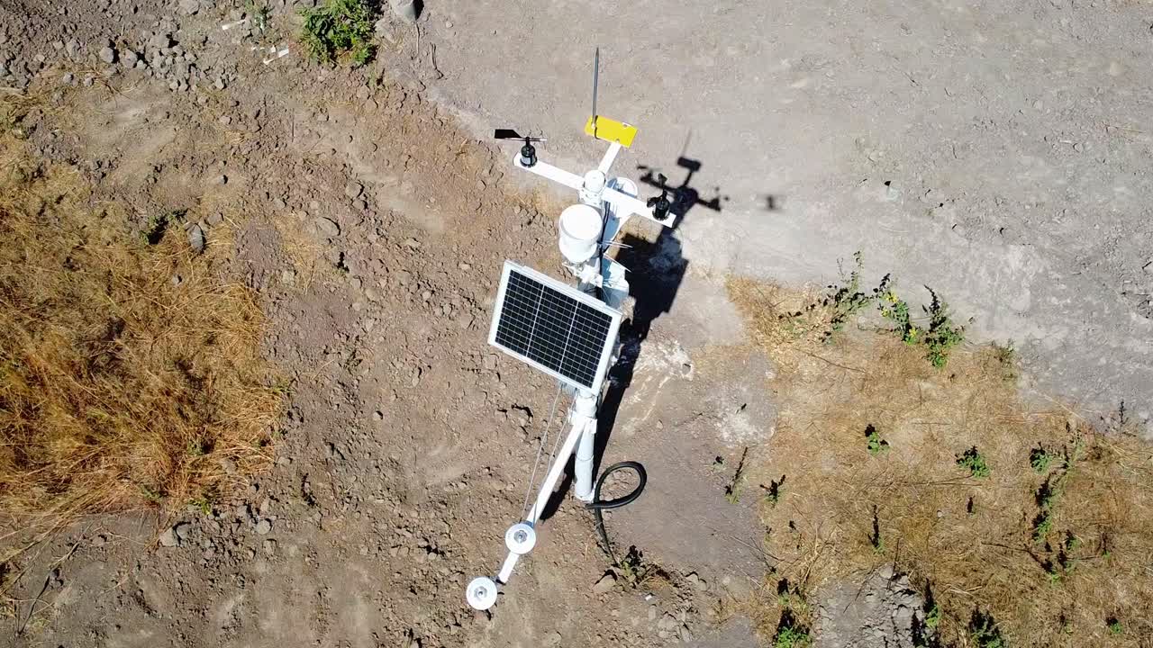Aerial closeup slow motion view of weather monitoring equipment and measuring devices for meteorological data collection