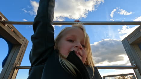 kid is hanging monkey bar at the playground
