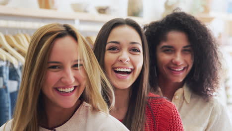 Portrait-Of-Three-Female-Friends-Having-Fun-Shopping-In-Clothes-Store-Together