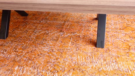 orange patterned rug under a wooden table