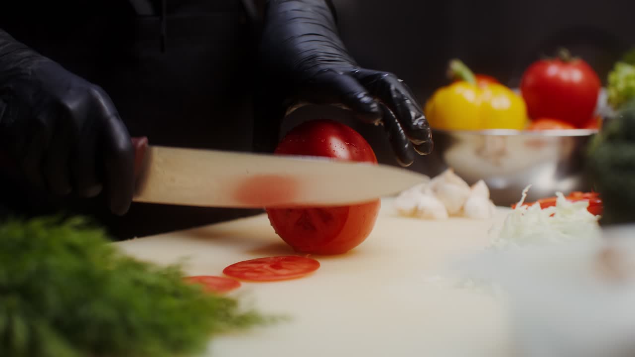 셰프가 토마토를 잘라내고 있습니다.
