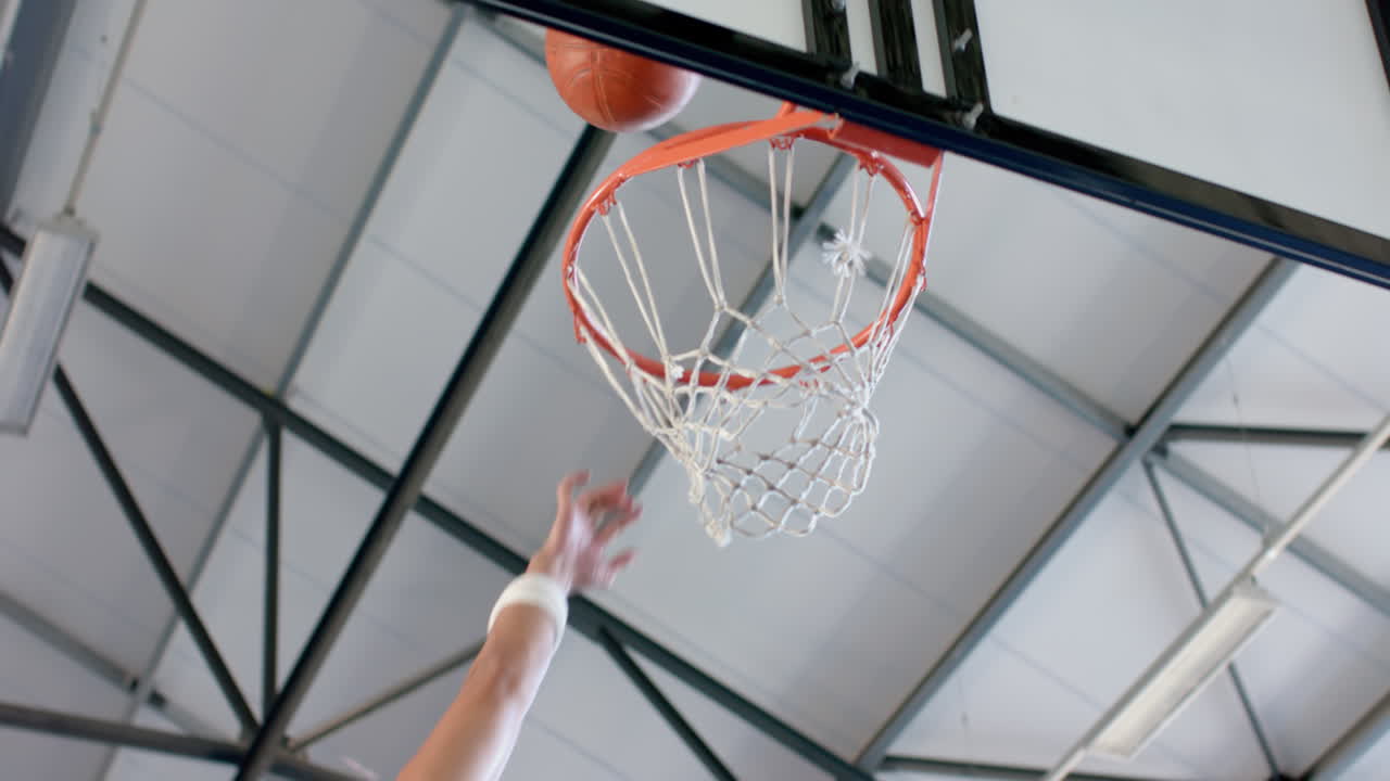 atleta anotando durante un juego de baloncesto, con espacio de copia