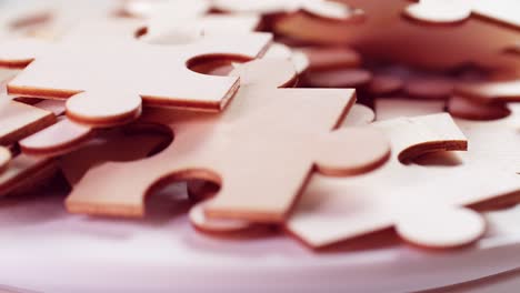 Closeup-of-Jigsaw-Puzzle-pieces-placed-on-a-turning-table-revealing-pieces-exposed-to-light-and-creating-shadows.