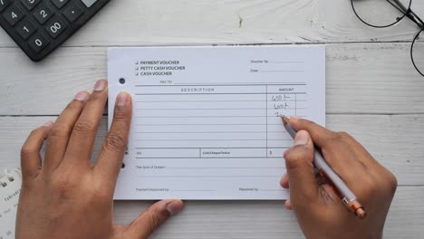 a man writes payment due in a paper form