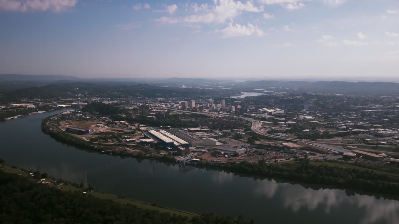Aerial view of downtown Chattanooga, Tennessee, showing the Tennessee River curving around the city’s industrial riverfront and urban core under hazy afternoon light
