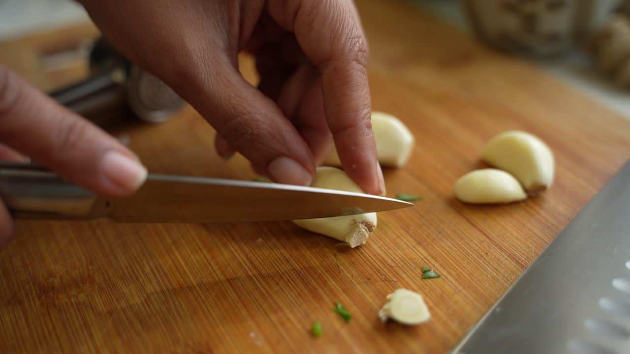 Cutting of garlic cloves using knife.