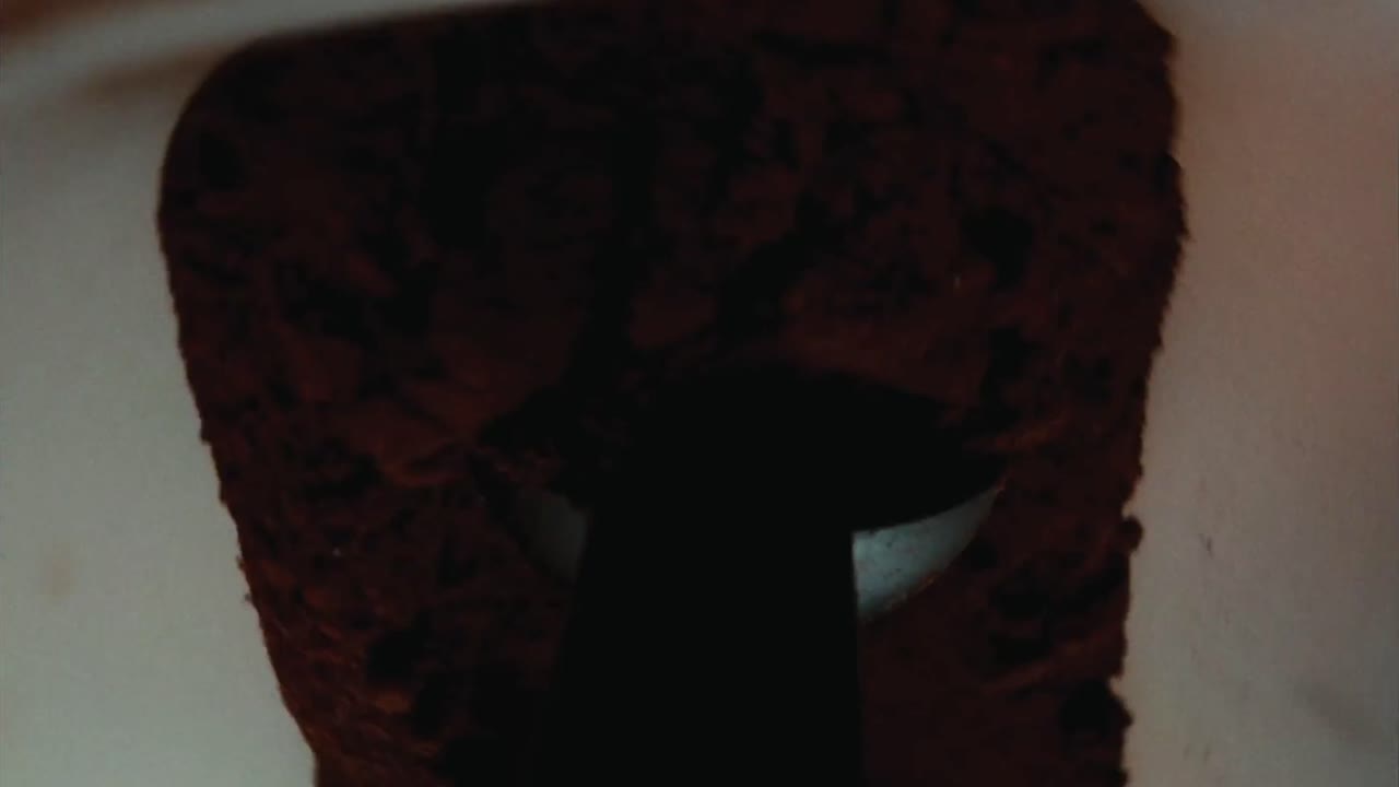 vista fija en la cuchara de café, recogiendo el polvo de café aromático y transfiriéndolo a un cuenco de metal, encarnando el ritual de la indulgencia y el viaje sensorial de la preparación del café