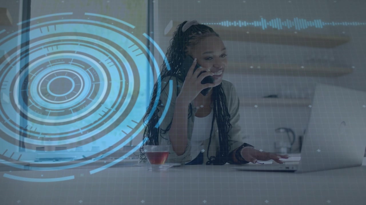 Woman answering phone call while typing on laptop, blue HUD and code overlay supporting remote work